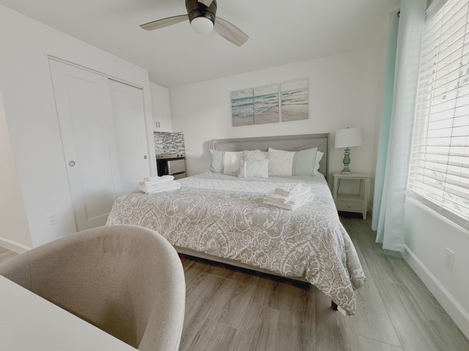 Bright Oceanside bedroom with coastal decor and a neatly prepared bed