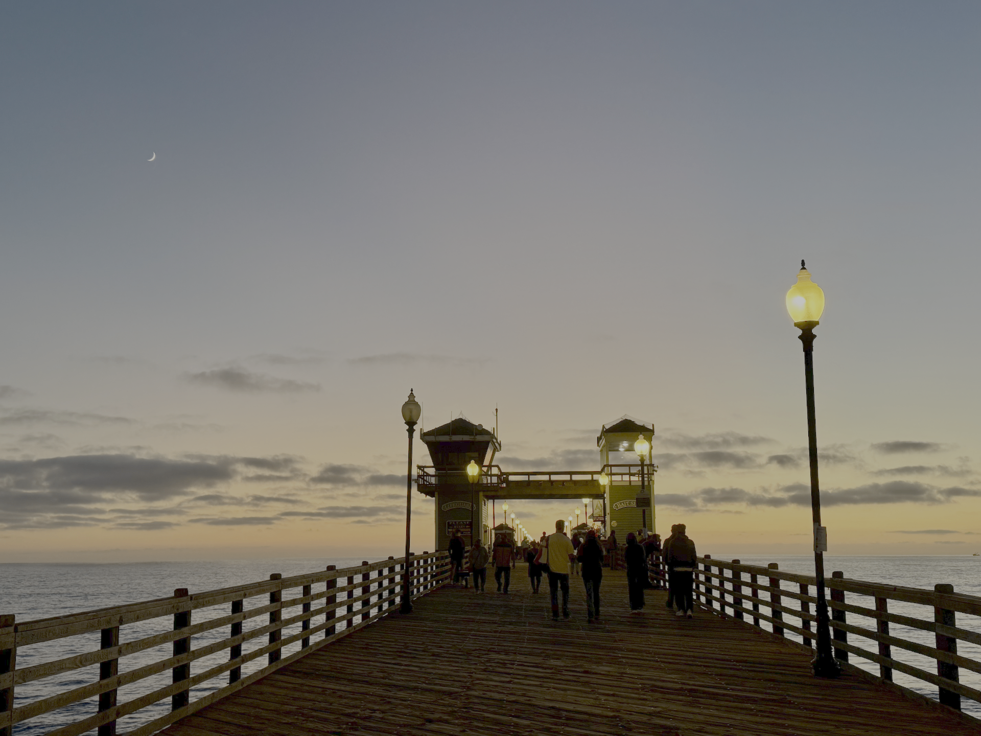 Evening walk on the Oceanside pier past the lifeguard tower and glowing street lamps